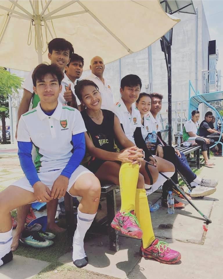 A group of soccer players are sitting under an umbrella