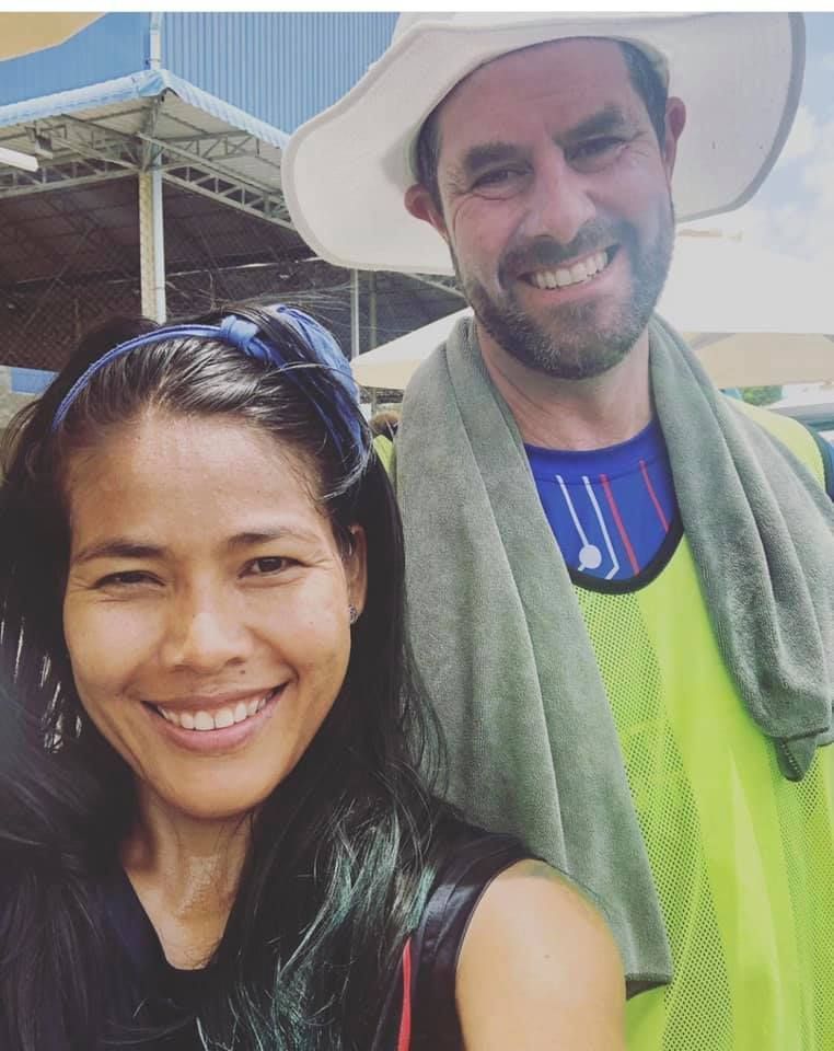 A man and a woman are posing for a picture and smiling