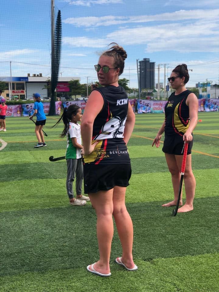 A woman in a number 21 jersey is standing on a field.