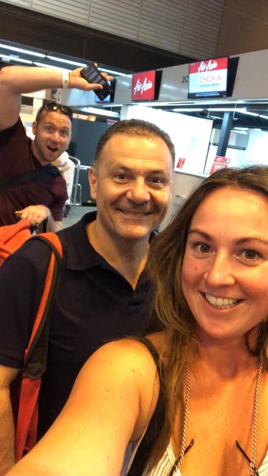 A man and a woman are taking a selfie at an airport
