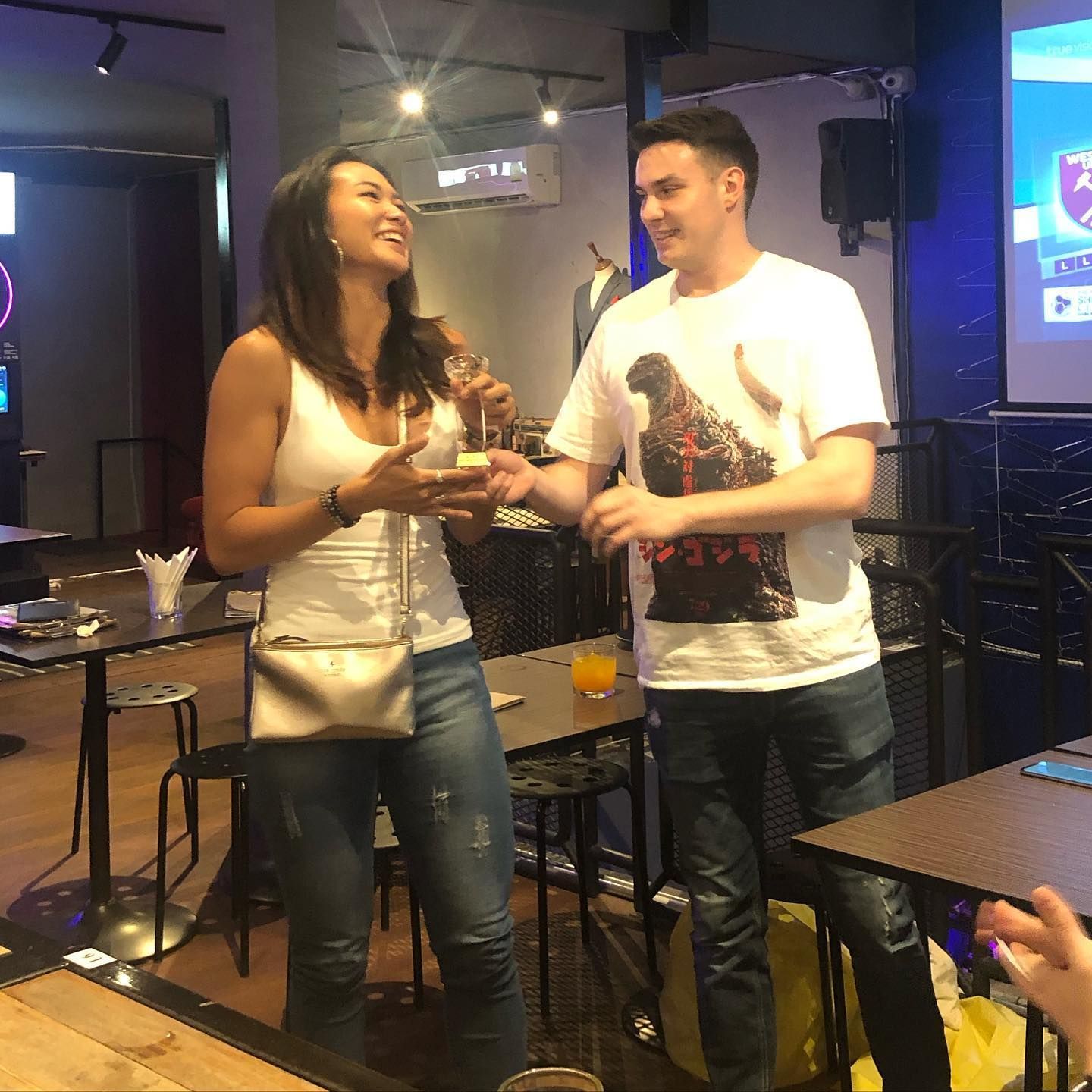 A man and a woman are standing next to each other in a restaurant