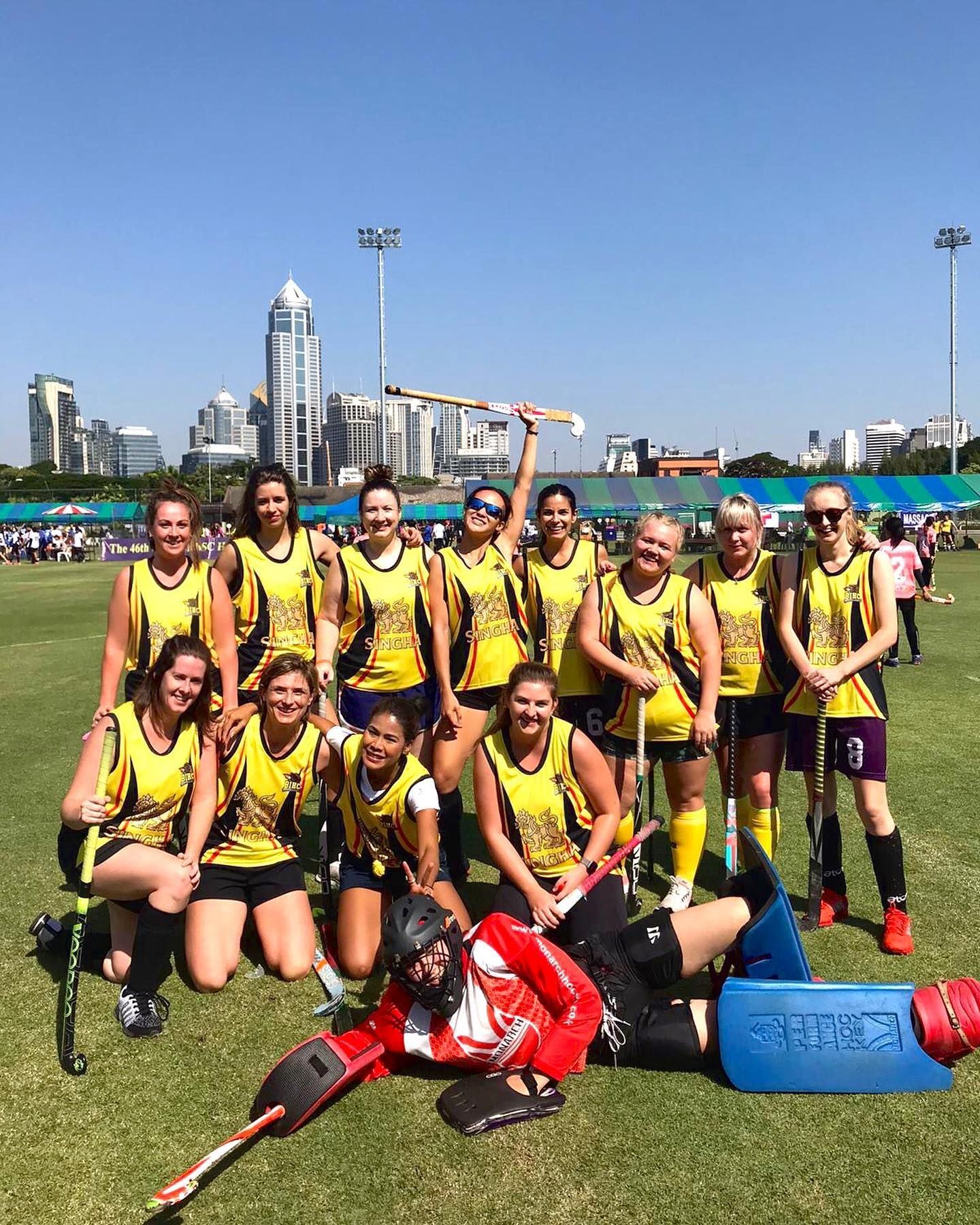 A group of women are posing for a picture on a field.