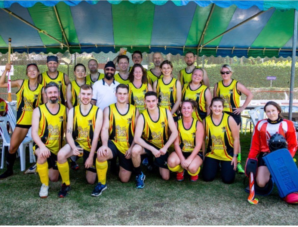 A group of people are posing for a picture under a tent.