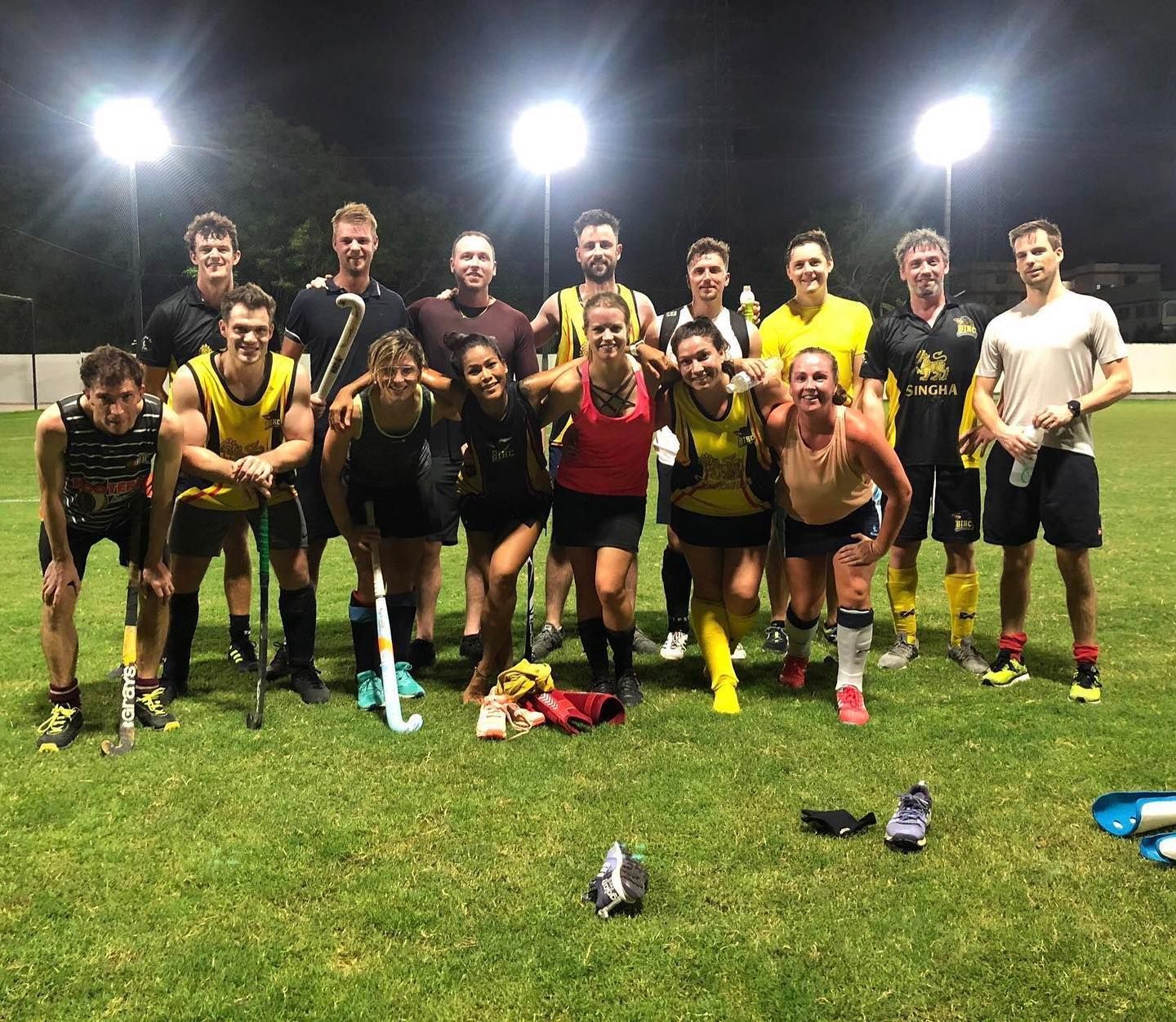 A group of people are posing for a picture on a field.