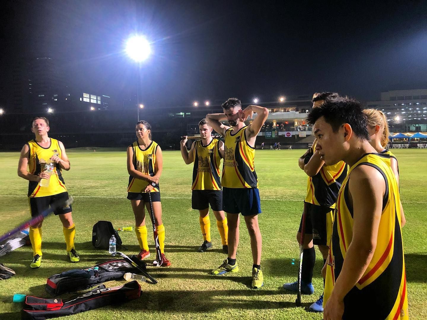 A group of people are standing on a field at night.