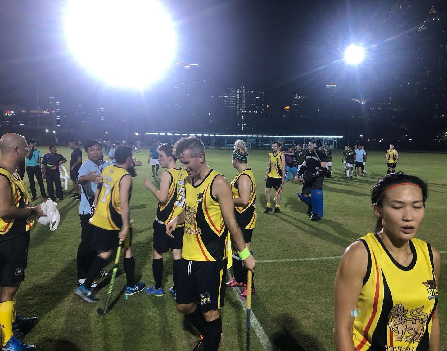 A group of people are standing on a field at night.