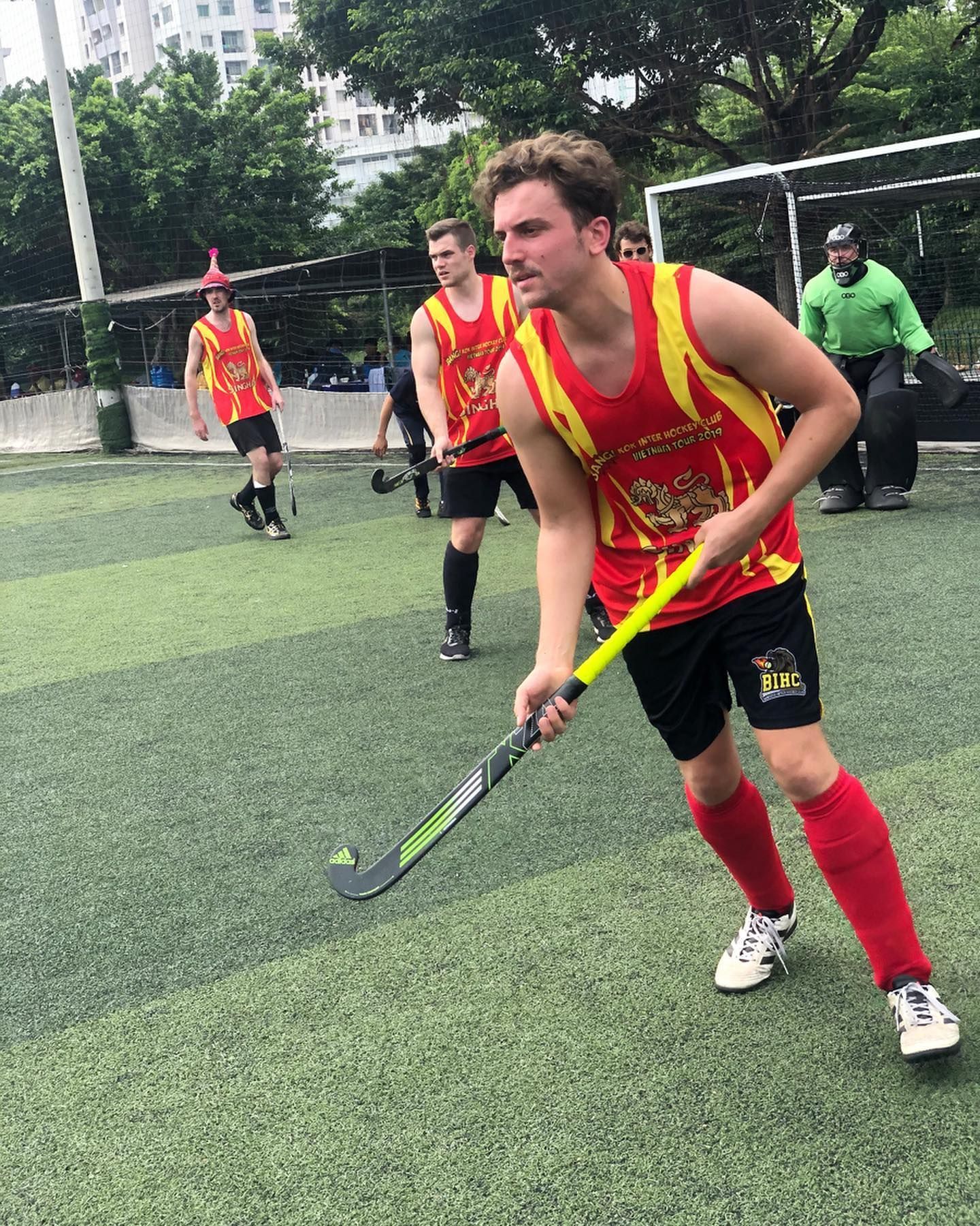A group of men are playing field hockey on a field.