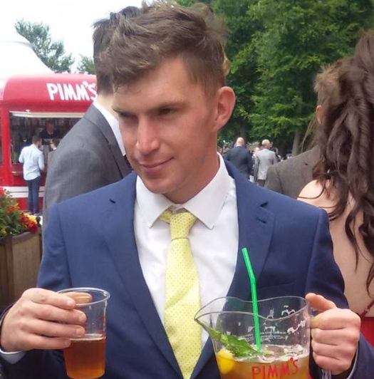 A man in a suit and tie is holding a drink in front of a pima 's food truck
