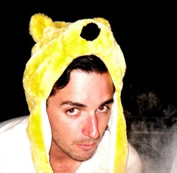 A man wearing a yellow teddy bear hat looks at the camera