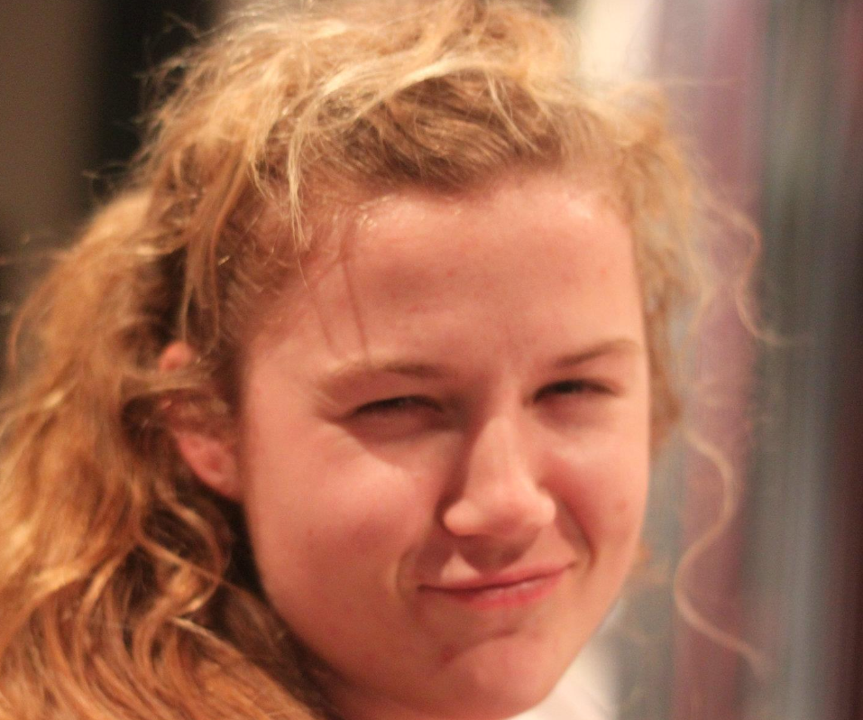 A close up of a woman 's face with a smile on her face