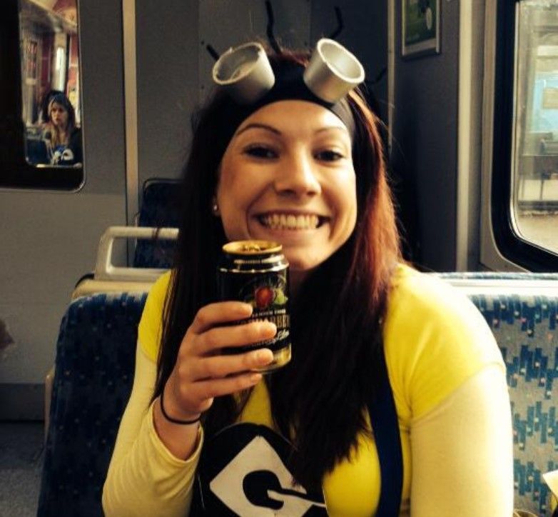 A woman in a minion costume is holding a can of gatorade