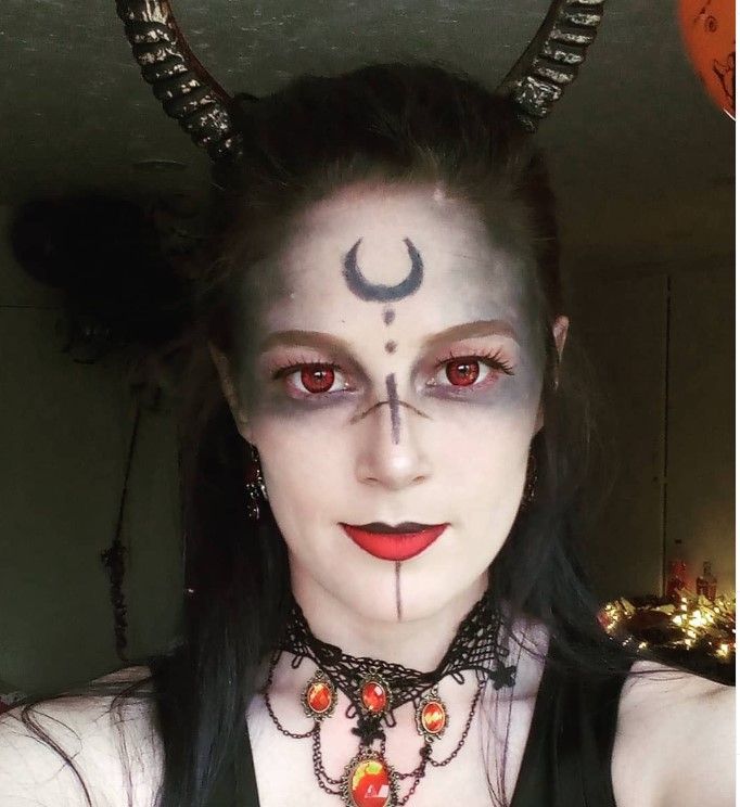 A woman with horns and a crescent moon on her face