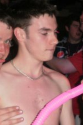 A shirtless man is holding a pink balloon