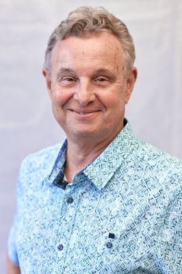 A man in a blue shirt is smiling for the camera.
