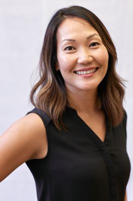 A woman in a black shirt is smiling for the camera.