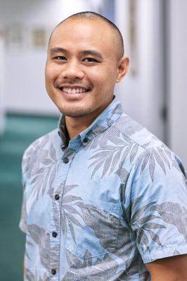 A man in a blue shirt is smiling for the camera.