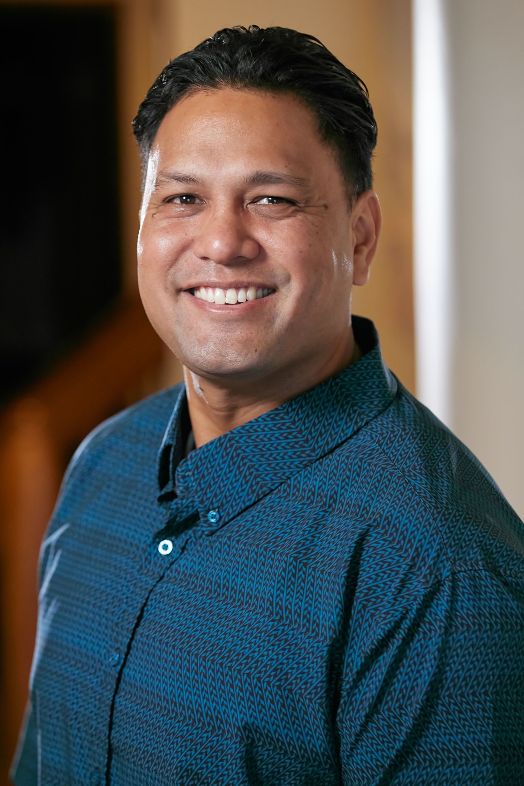 A man in a blue shirt is smiling for the camera.