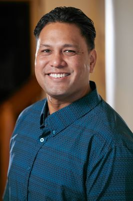 A man in a blue shirt is smiling for the camera.