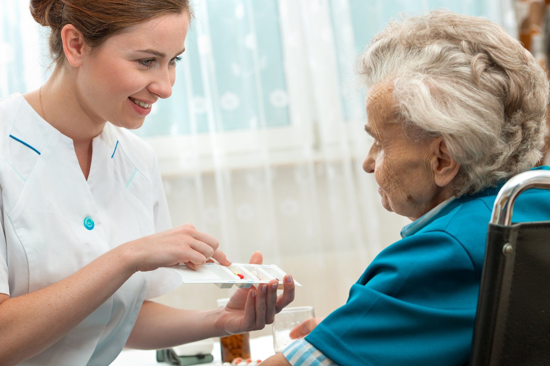 Enfermera administrando medicacion a un adulto mayor