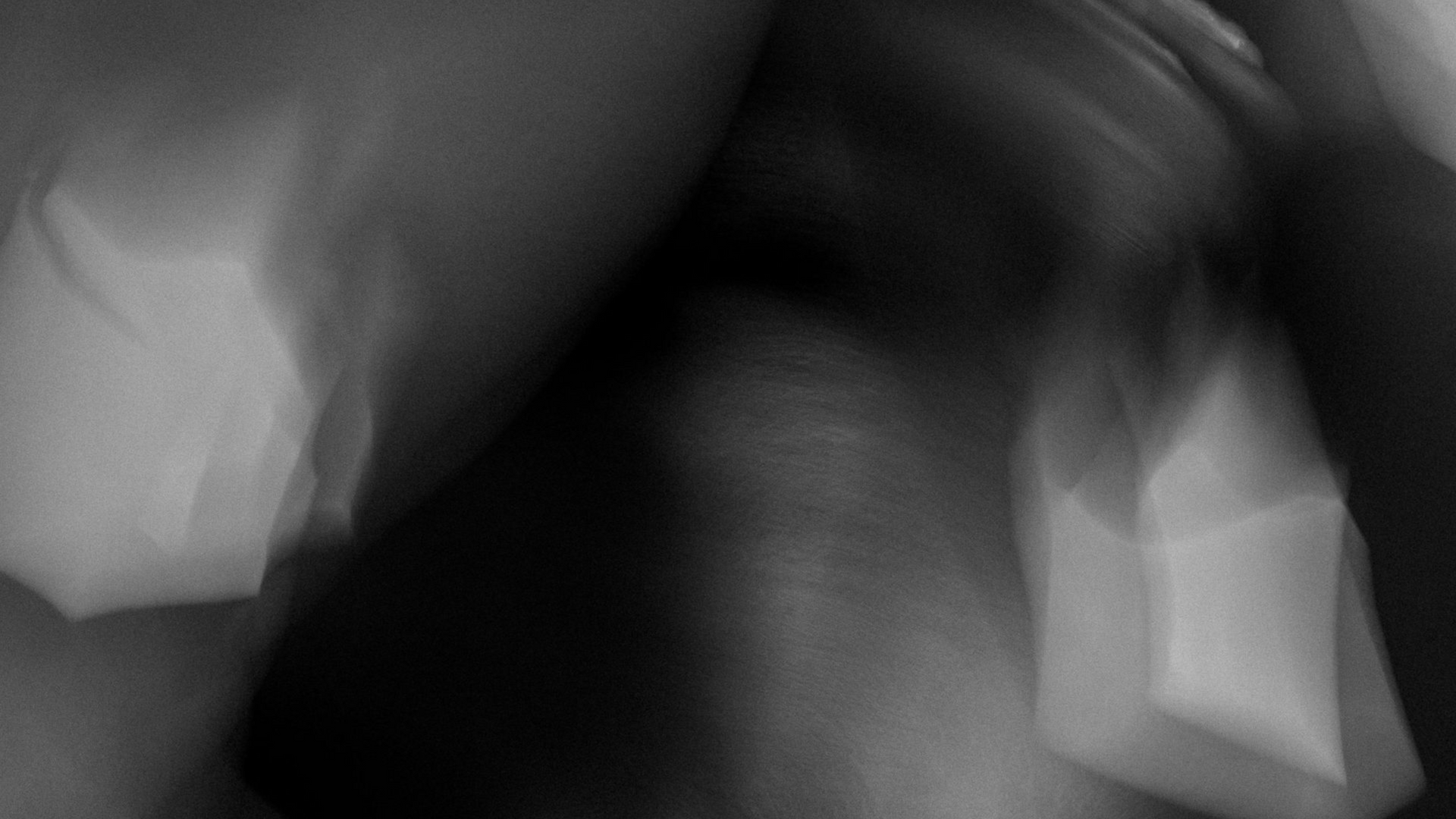 Abstract, blurred black and white image. Shadows and highlights create amorphous shapes with indistinct edges.