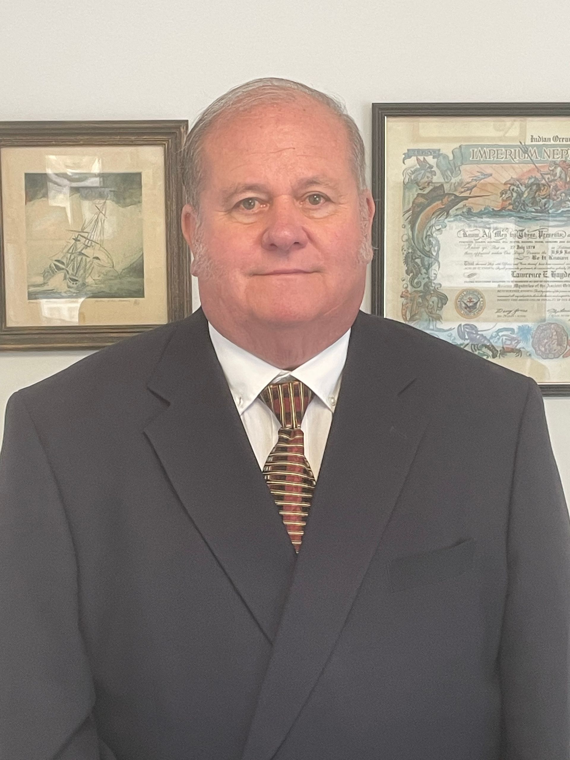 Gavel on block, scales of justice, person in suit reading documents at desk.