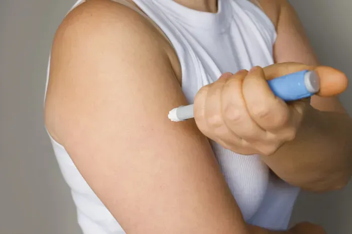 a person is injecting a semaglutide weight loss dose into their arm