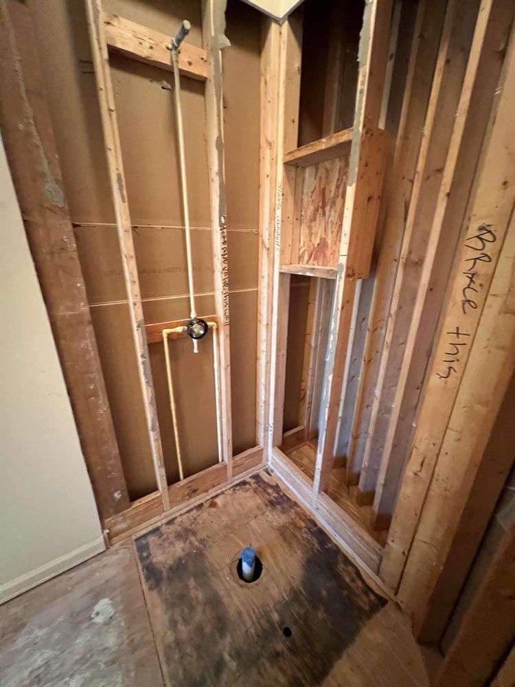 A bathroom under construction with a drain hole in the floor.