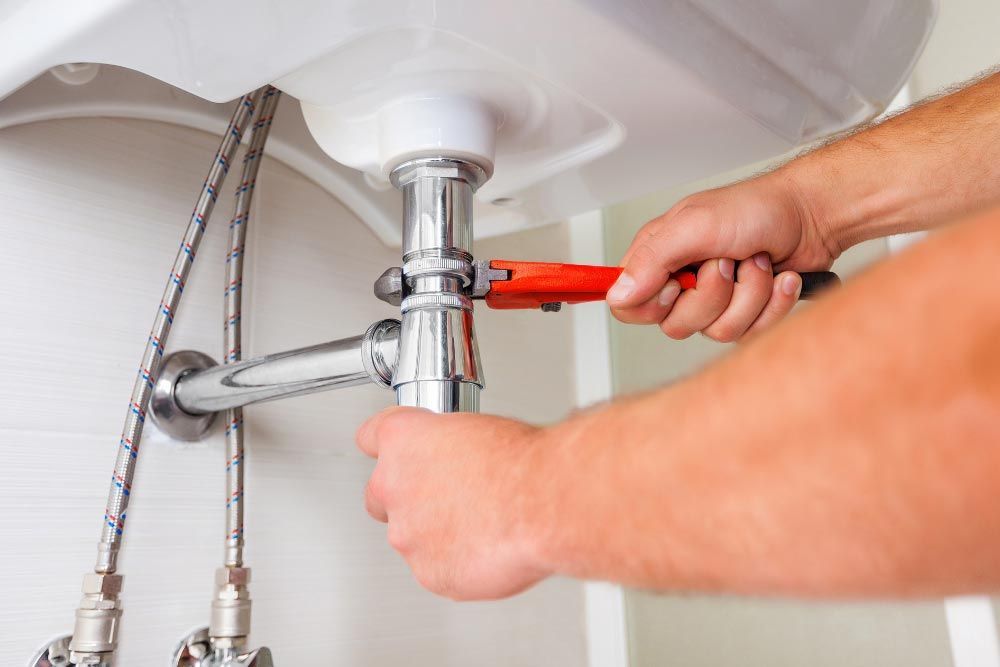 Plumber replacing pipe on the sink
