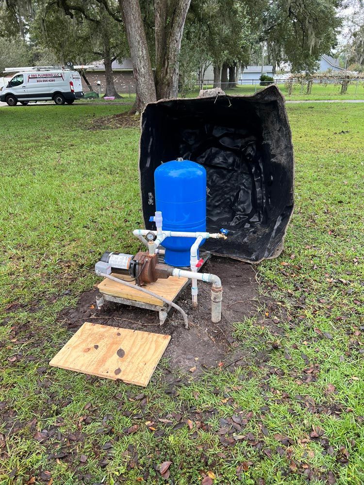 A blue water tank is sitting in the middle of a grassy field.