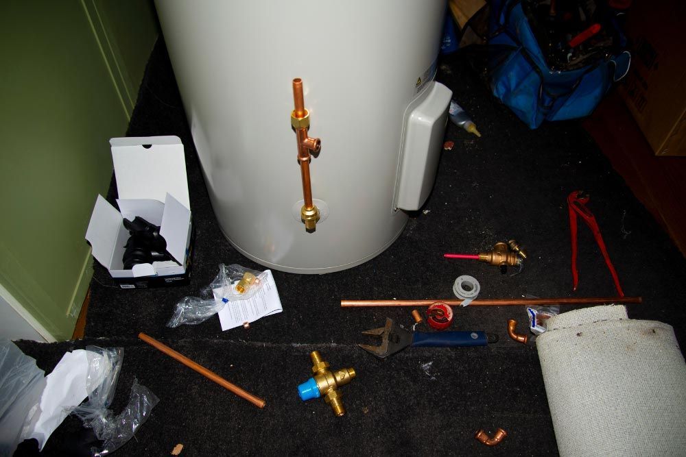 White water heater and tools on the ground