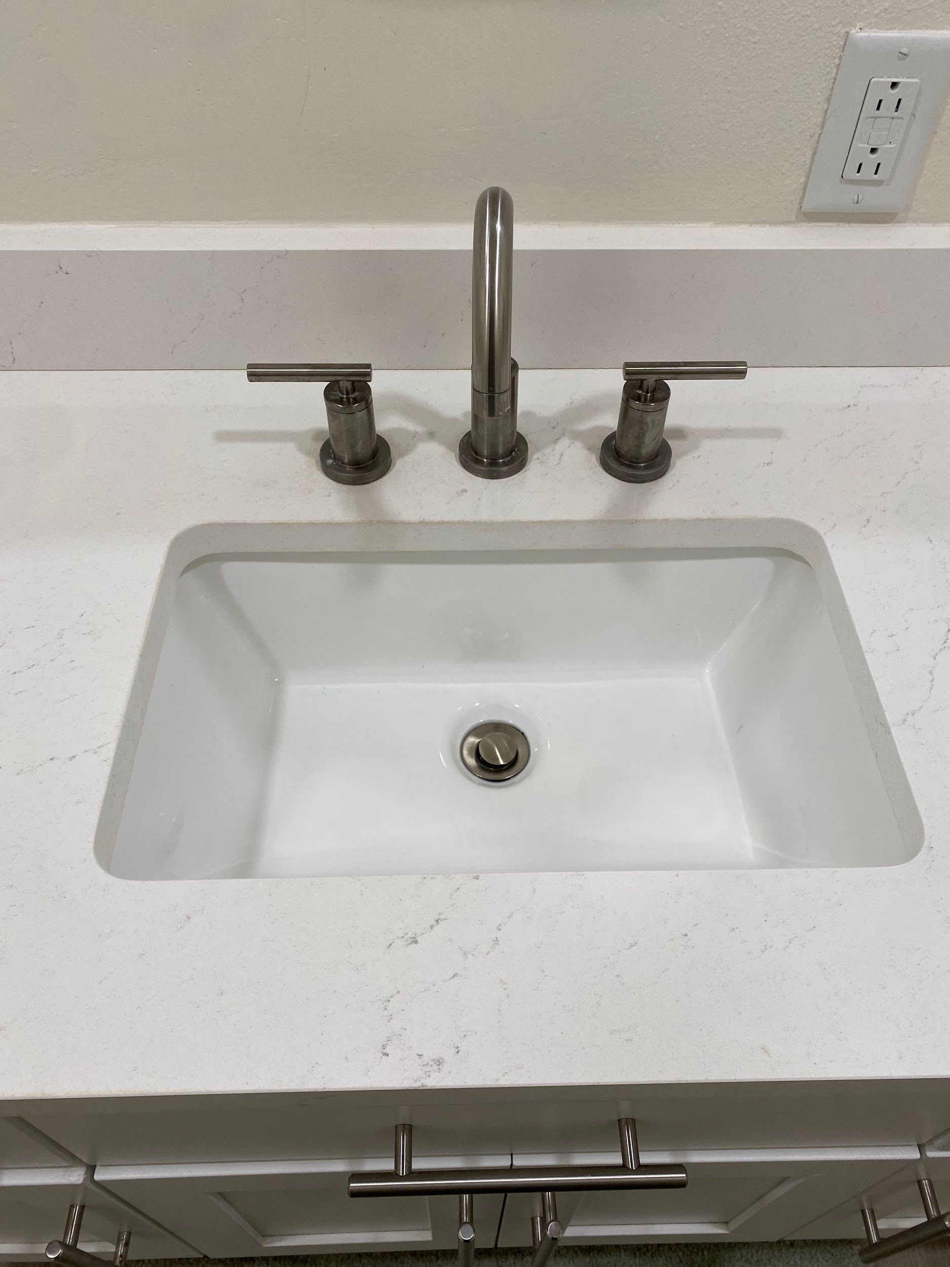 A bathroom sink with a faucet on a white counter top.