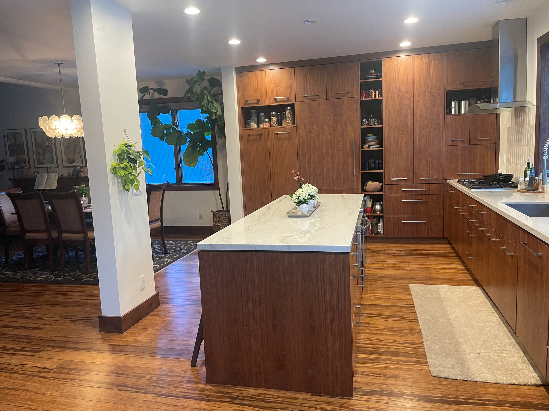 A kitchen with wooden cabinets and a large island in the middle.
