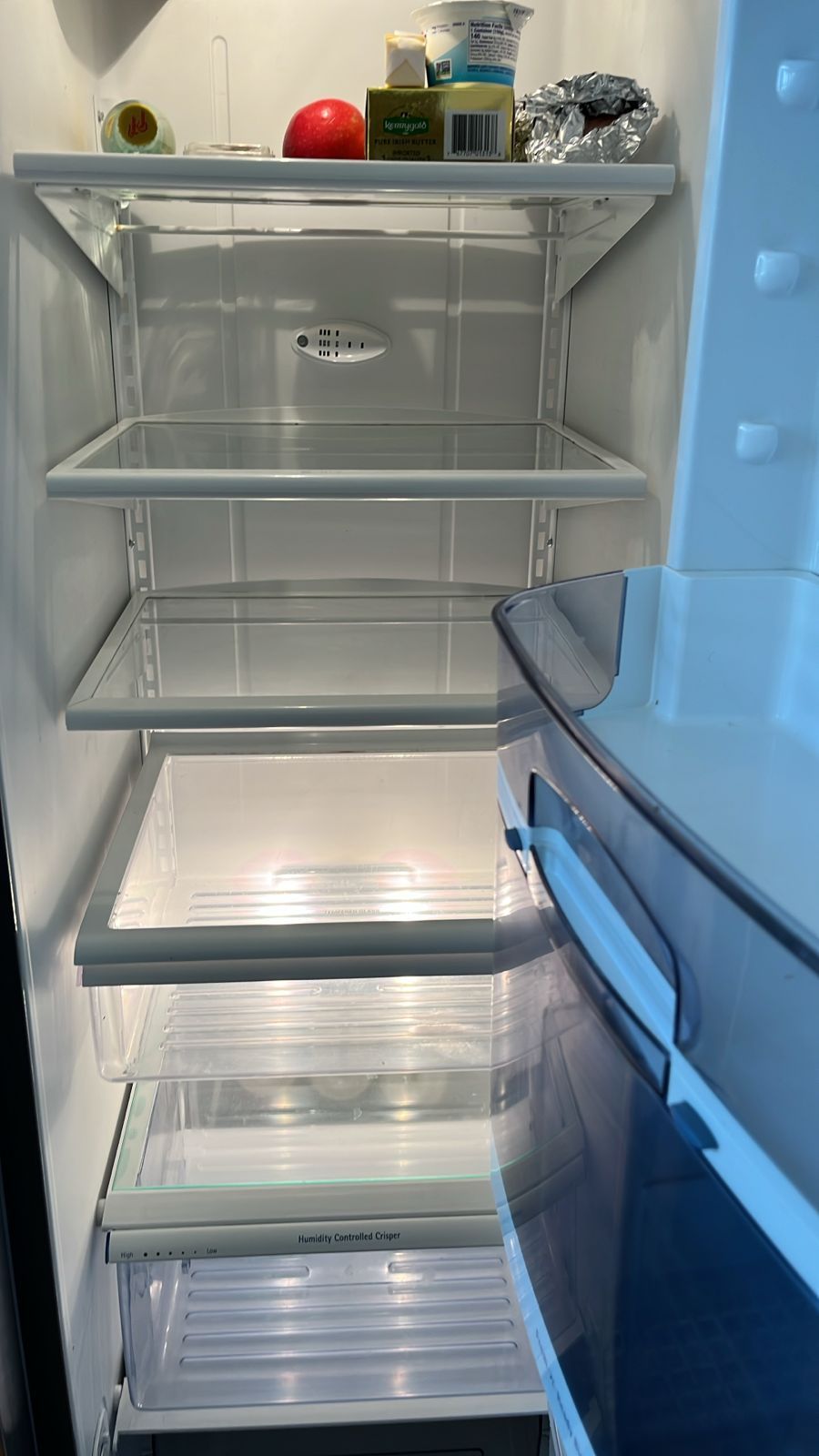 The inside of an empty refrigerator with a lot of shelves.