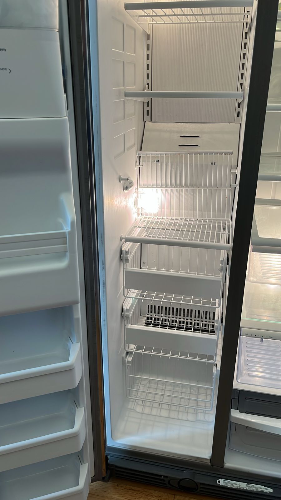 The inside of an empty refrigerator with the door open.