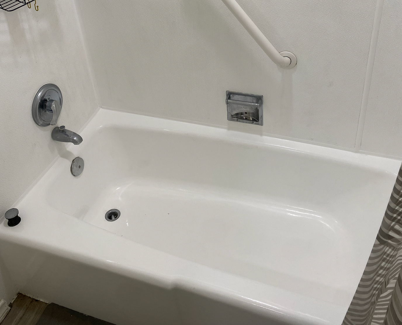 A white bathtub is sitting in a bathroom next to a shower.