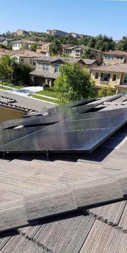 A row of solar panels are sitting on top of a wooden roof.