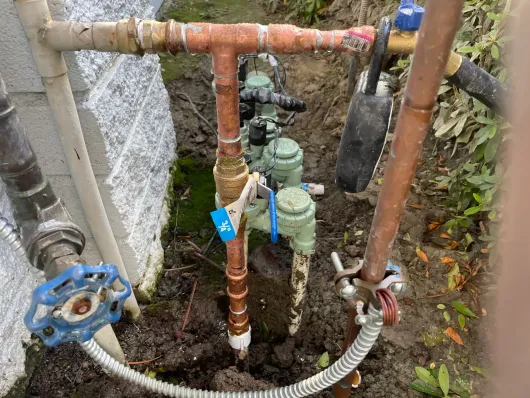 A bunch of pipes are connected to each other in the dirt.