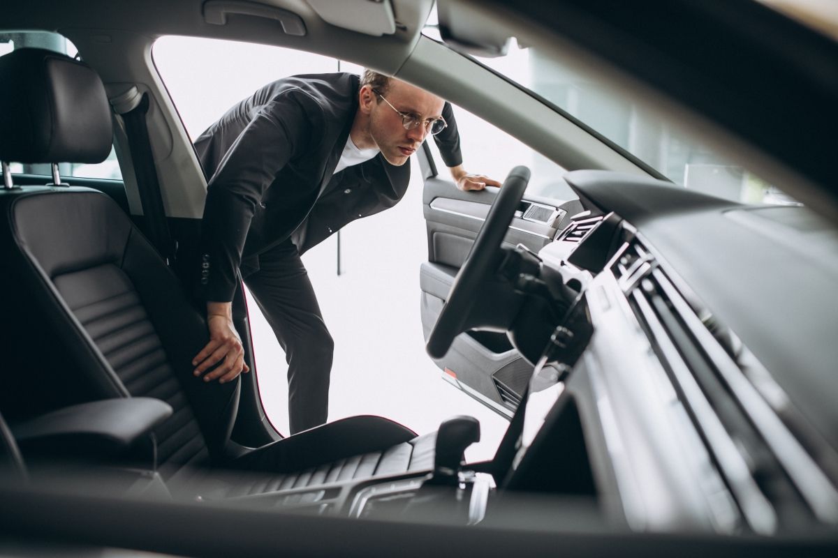 a man is looking into the interior of a car