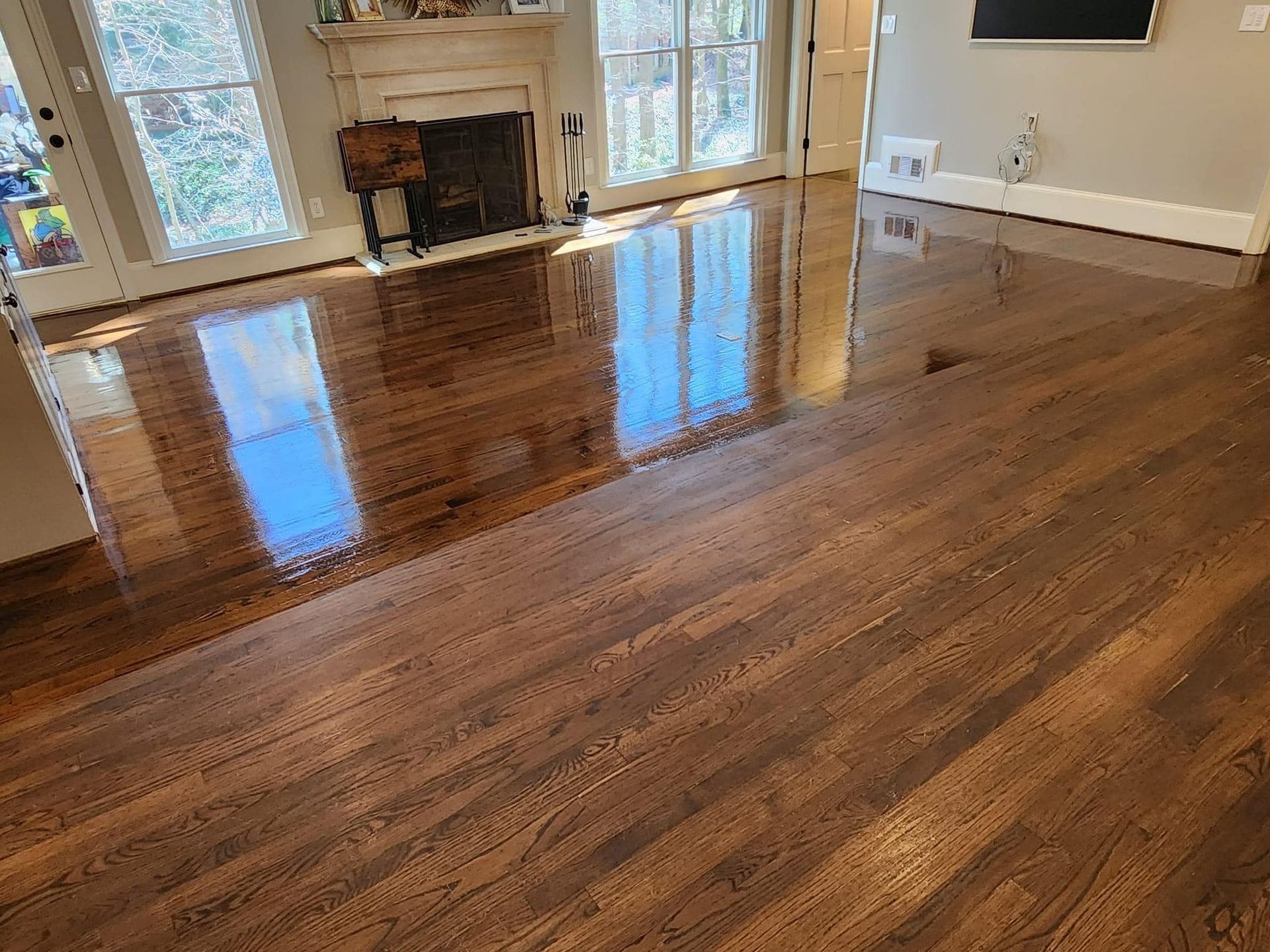 A living room with hardwood floors and a fireplace.