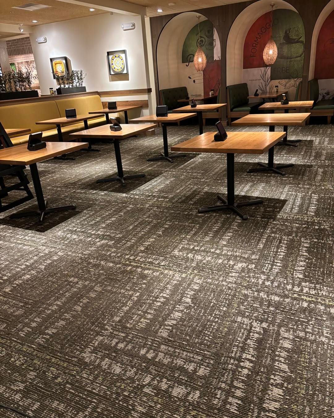 A restaurant with tables and chairs and a carpeted floor.
