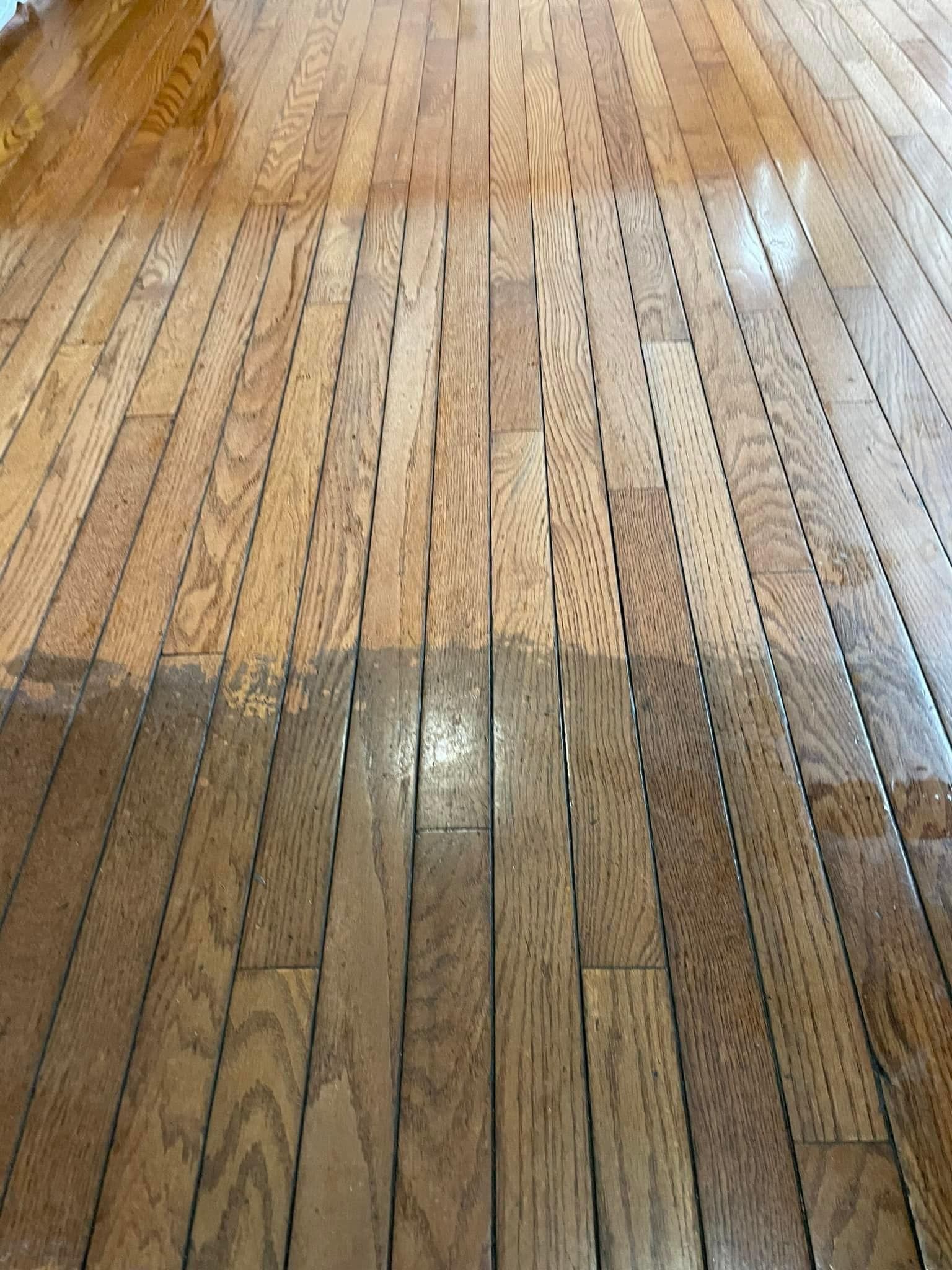 A close up of a wooden floor with a stain on it.