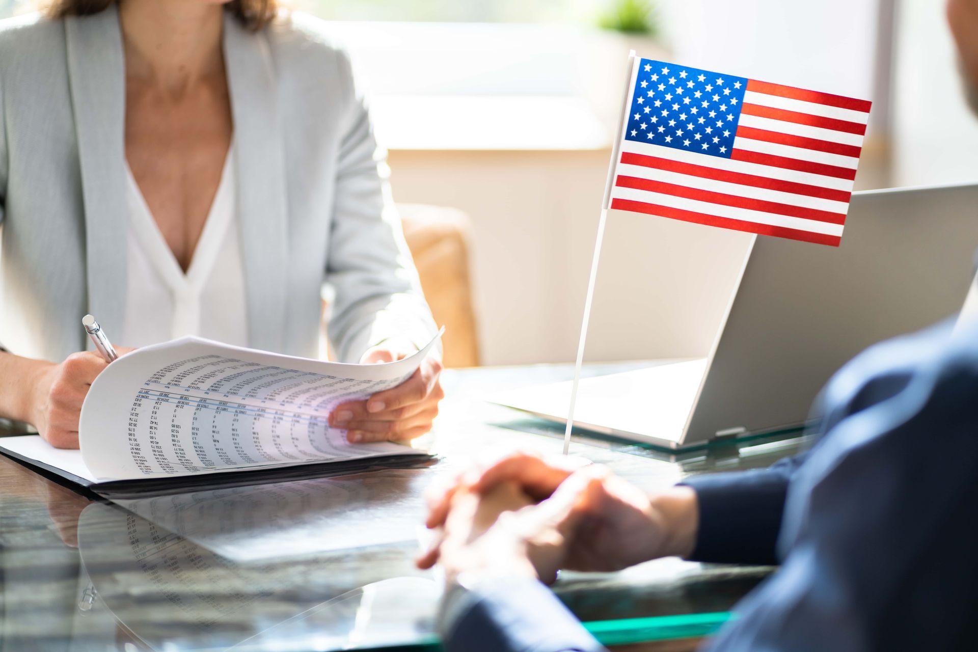 Hands exchanging a passport and clipboard during an ID check at a desk