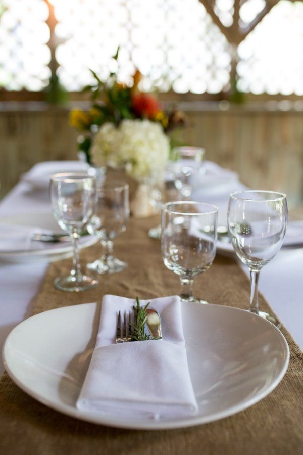 A white plate with a napkin and fork on it is on a table.