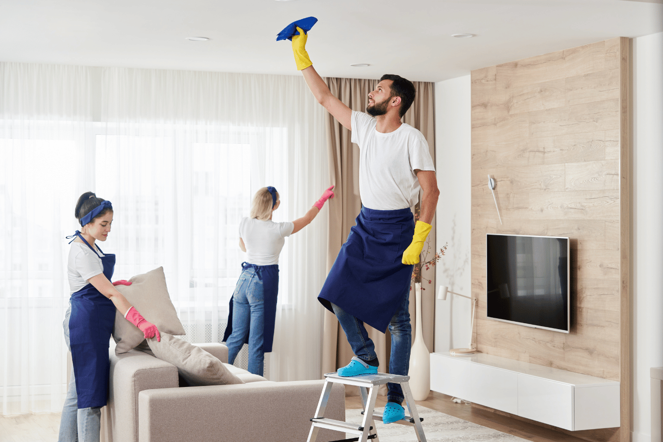 A group of people are cleaning a living room.