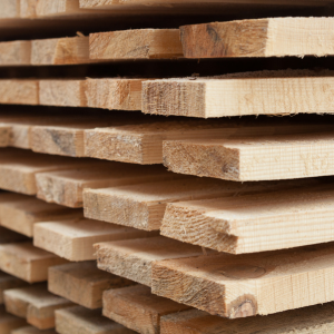 Stacked wooden planks with rough-cut edges, viewed in close-up.
