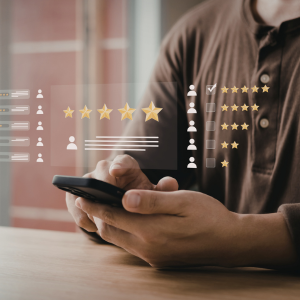 Person holding a smartphone with star ratings and review icons overlaid on screen