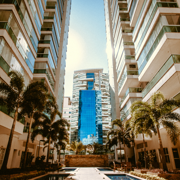 A row of tall buildings with a pool in the middle