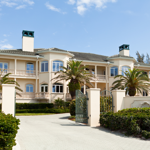 A large white house with palm trees in front of it
