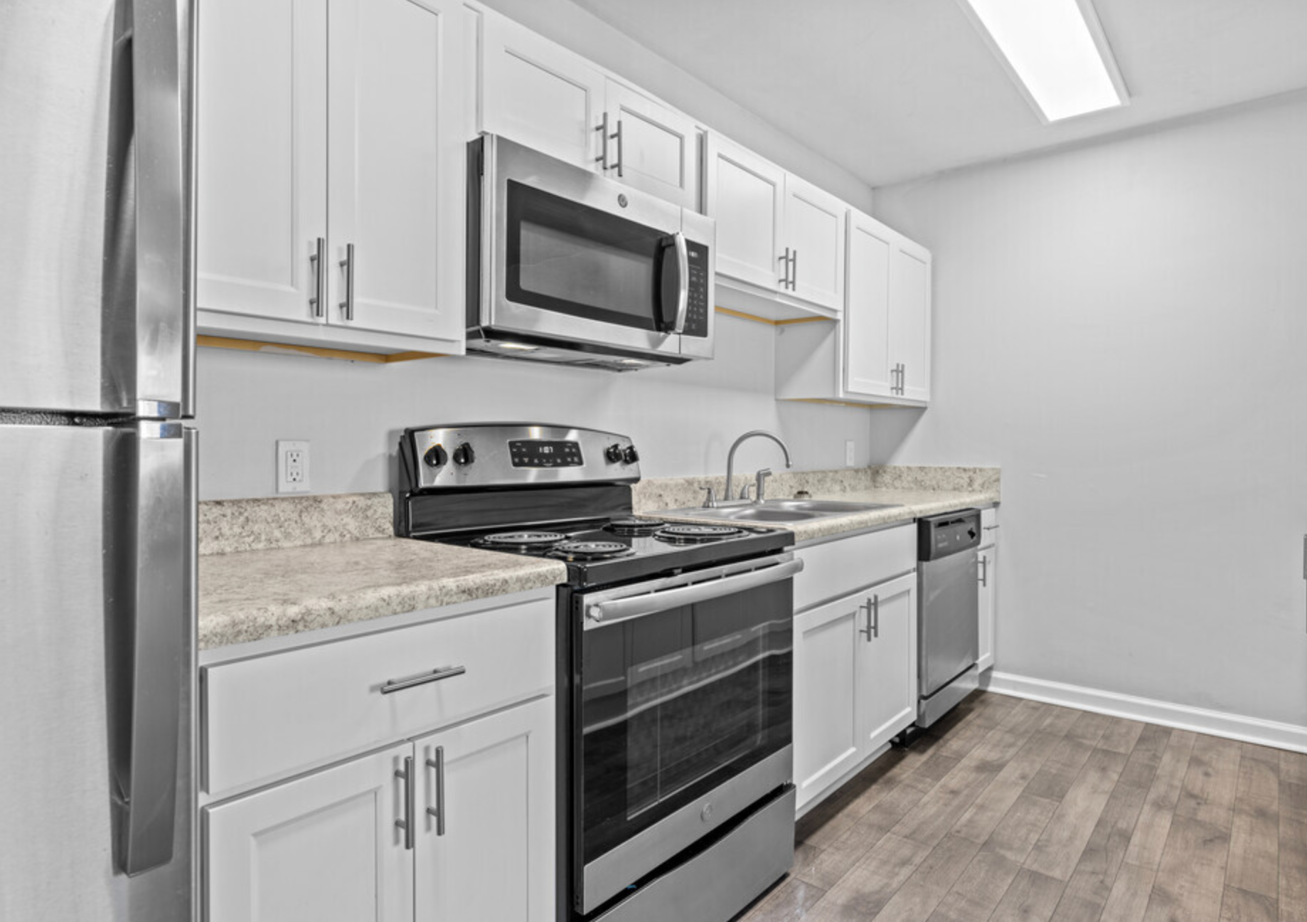 A kitchen with stainless steel appliances and white cabinets.