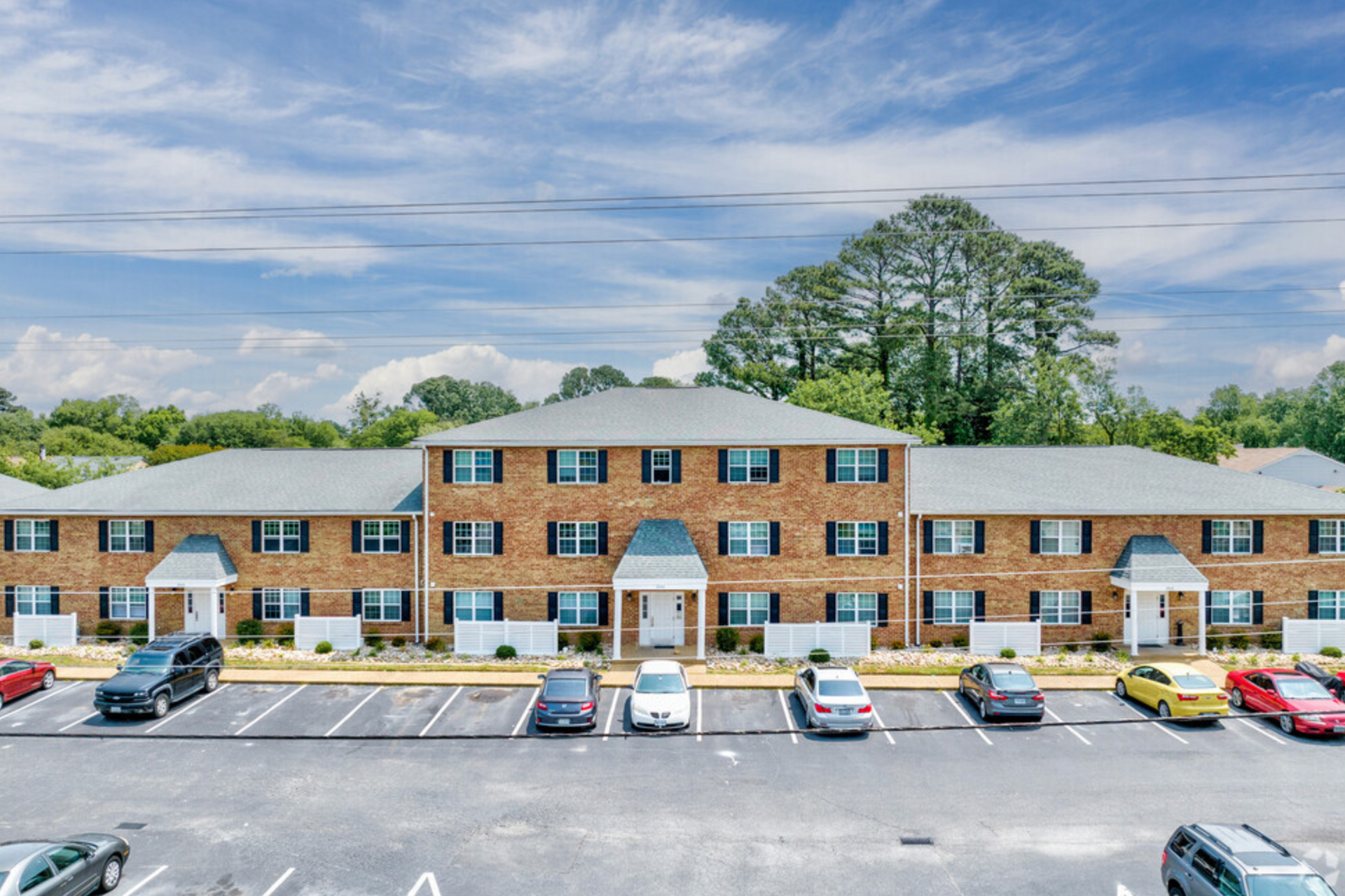 A large apartment building with cars parked in front of it